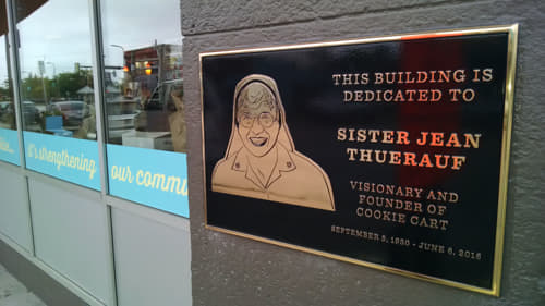 Bronze plaque dedicating a building to Sister Jean Thuerauf, founder of Cookie Cart.